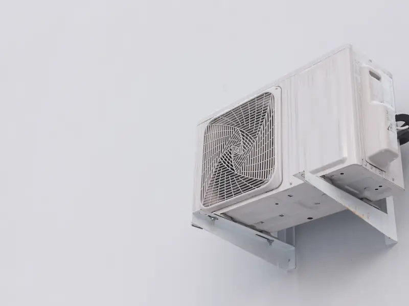 Groupe extérieur de climatisation posé sur un support mural surélevé