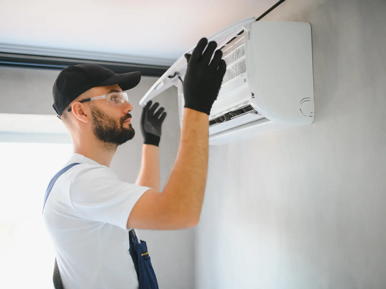 Intervention d'un technicien sur un climatiseur mural dans un logement proche de la mer