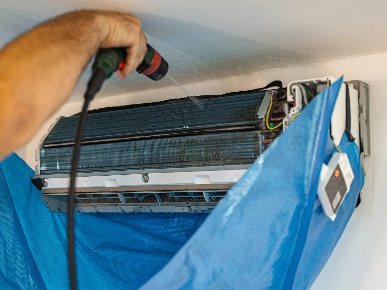 Nettoyage d'une climatisation murale sous housse de récupération