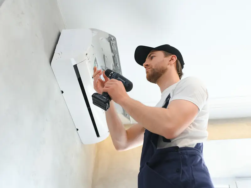Perçage du mur pour fixer la nouvelle unité intérieure d'une climatisation