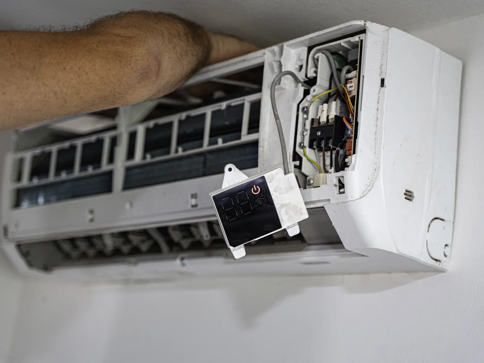 Technicien contrôlant la carte électronique d’un climatiseur qui signale un défaut