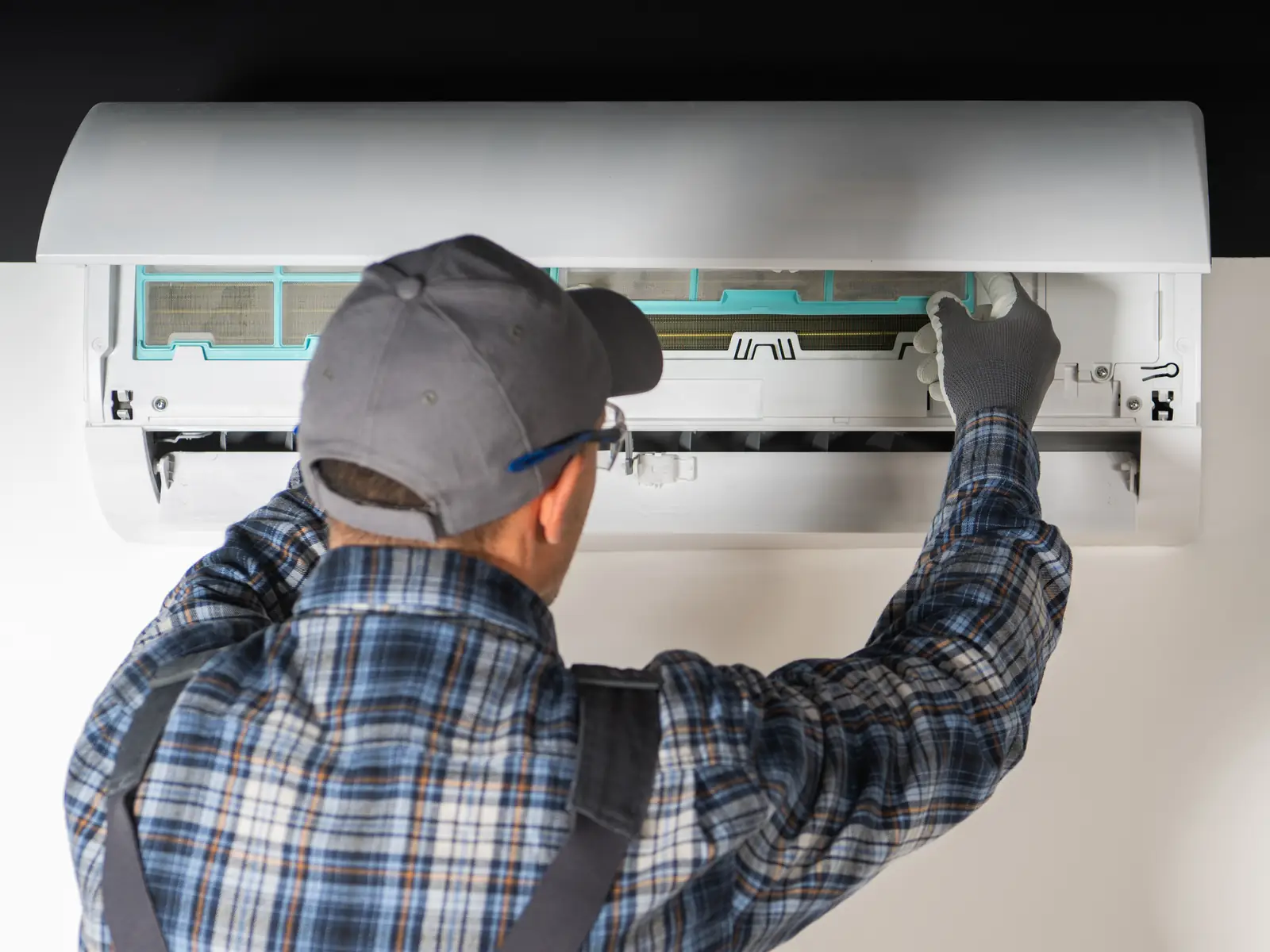 Technicien contrôlant une unité intérieure de climatisation avant la saison chaude