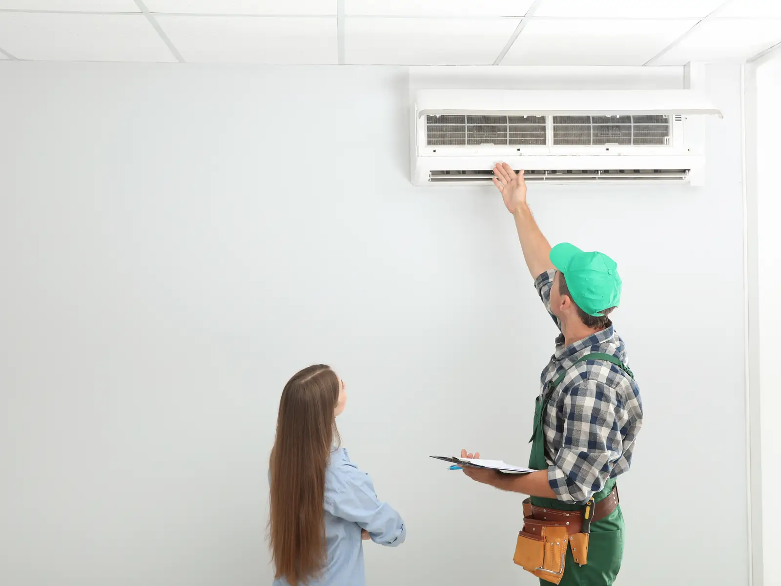 Technicien expliquant à une cliente l'entretien de sa climatisation