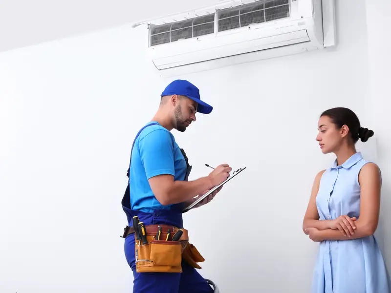Technicien expliquant à une cliente la panne de sa climatisation