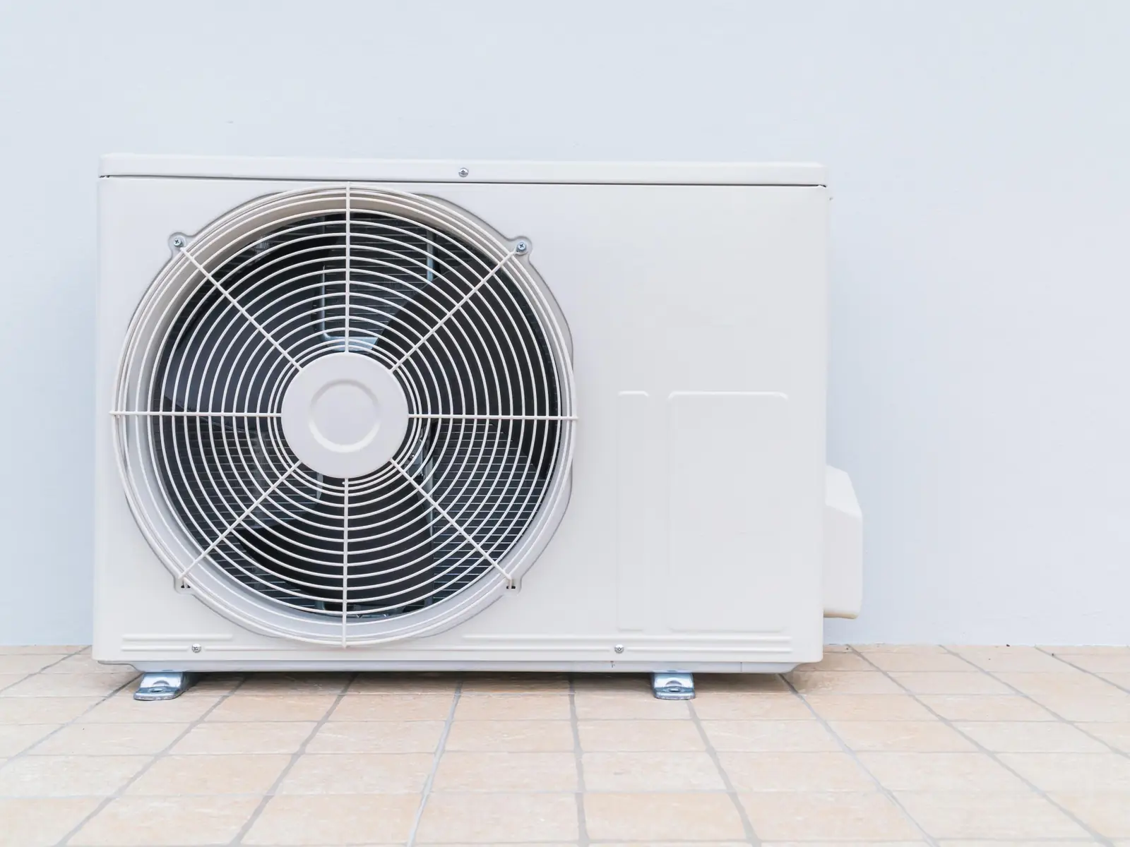 Unité extérieure de climatisation posée au sol, reliée au système intérieur